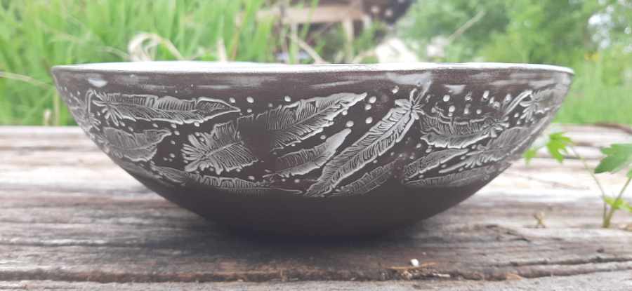 Keramikprodukt von Claudia Entner - schwarze Schüssel, innen weiß glasiert, außen Federnmotiv eingestempelt, dass mit weißer Glasur ausgefüllt ist